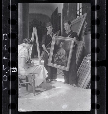 MADRID—A woman taking inventory of the paintings in the collection of Las Descalzas Reales with two Republican soldiers, October/November 1936. © David Seymour / Magnum Photos